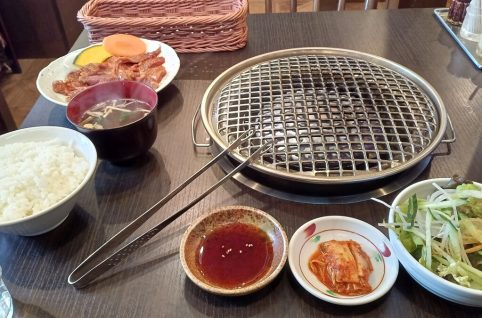 焼き肉こぶたジンギスカン定食。焼き網、ごはん、肉、キムチ、野菜サラダ