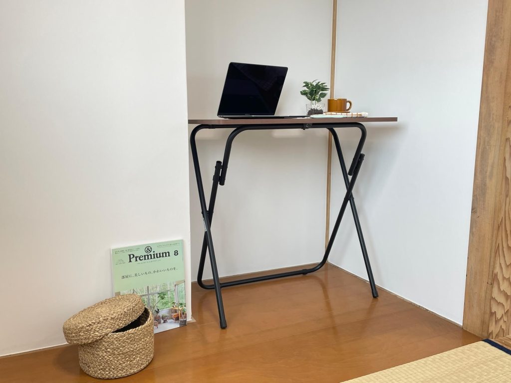 書斎の板の間スペースにテーブル上にはノートPCとマグカップ