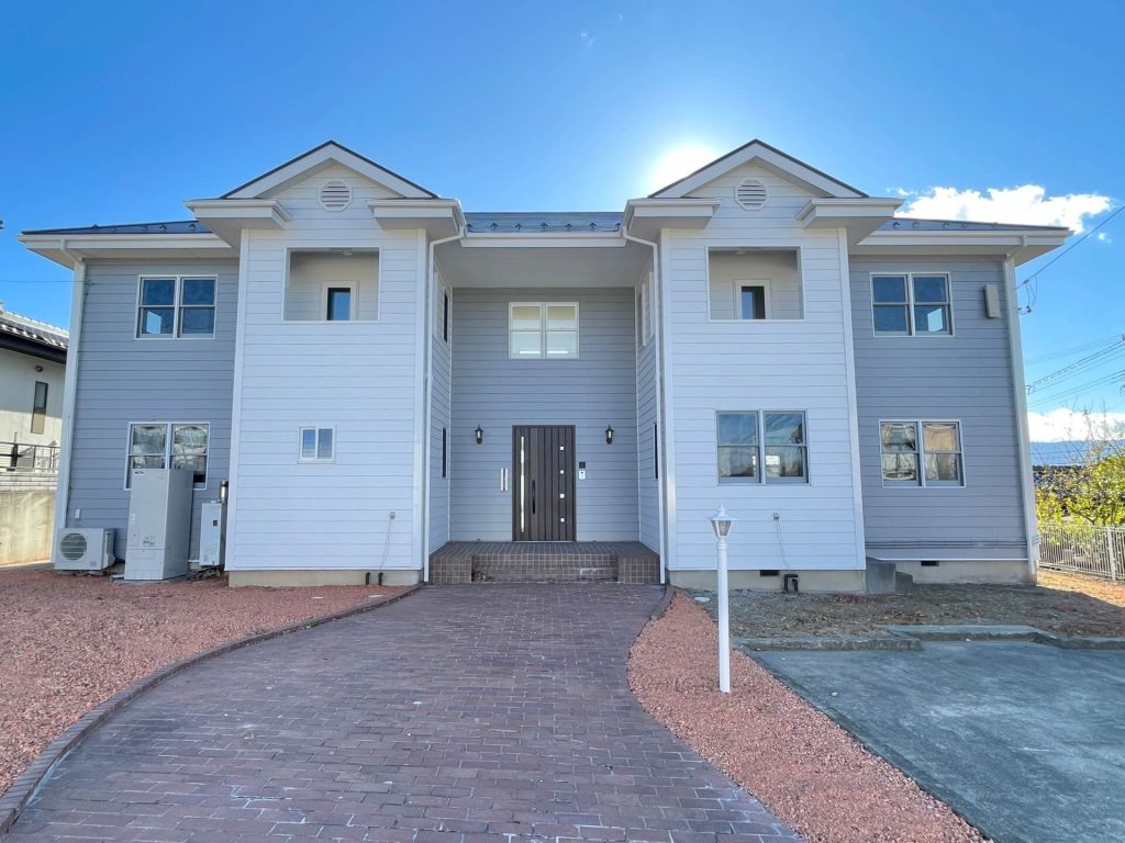 松本市内田のリフォーム済み中古一戸建て住宅です。シンメトリーな建物に、石畳のアプローチは海外を思わせます。